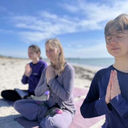 Girls meditating on beach