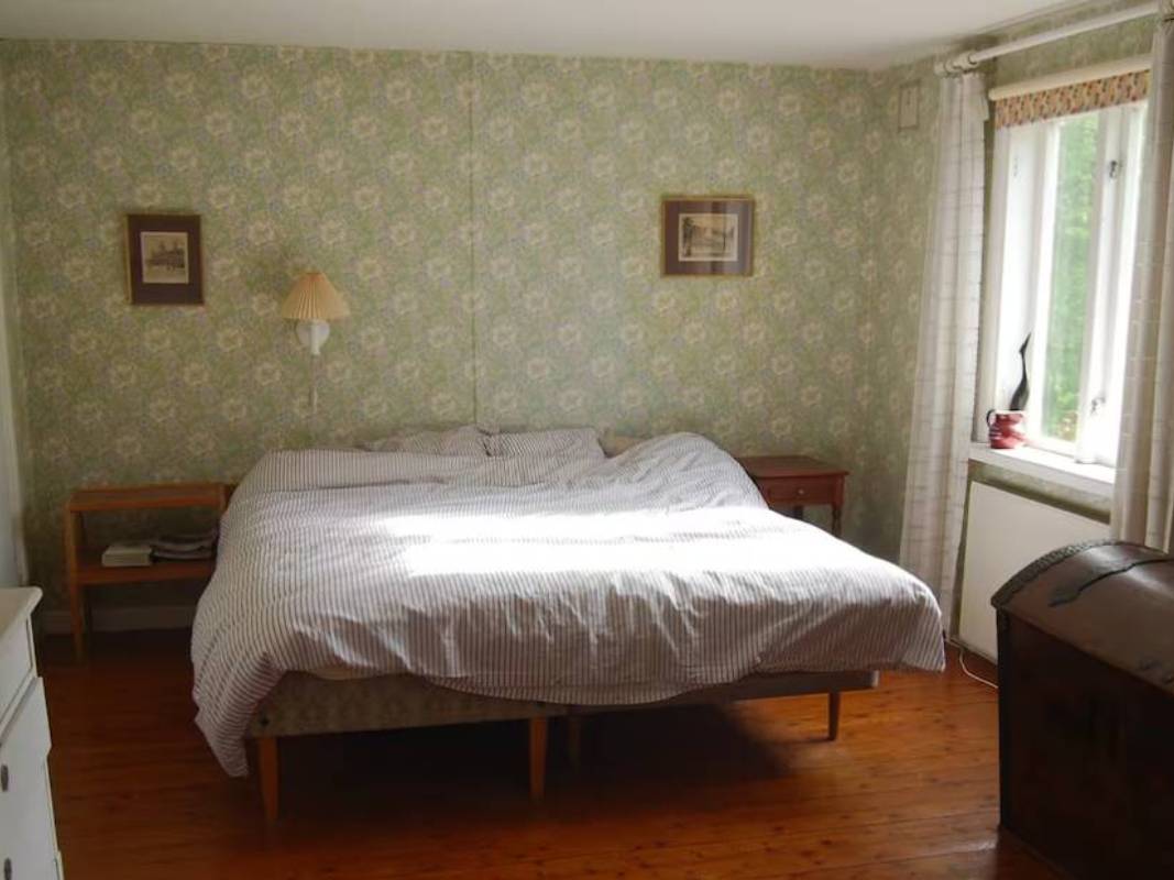 Master bedroom at Yogi Living retreat center in Skåne, Sweden, surrounded by serene forest views.