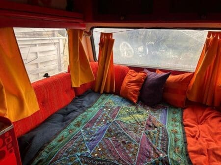 Comfortable bed in the Boho Caravan at Yogi Living retreat center in Skåne, Sweden, perfect for restful sleep