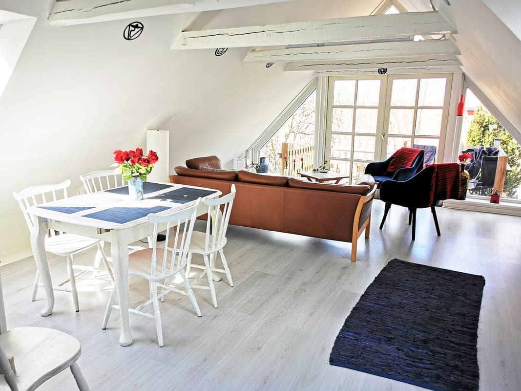 Comfortable lounge with balcony view at Yogi Living Guesthouse in Skåne, Sweden