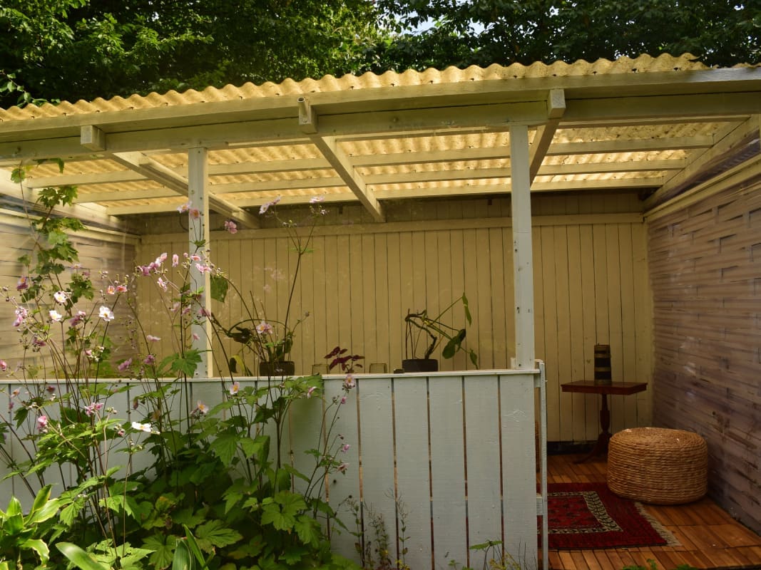 Guests enjoying tea outdoors at Yogi Living Boho Caravan in Skåne, Sweden, surrounded by nature
