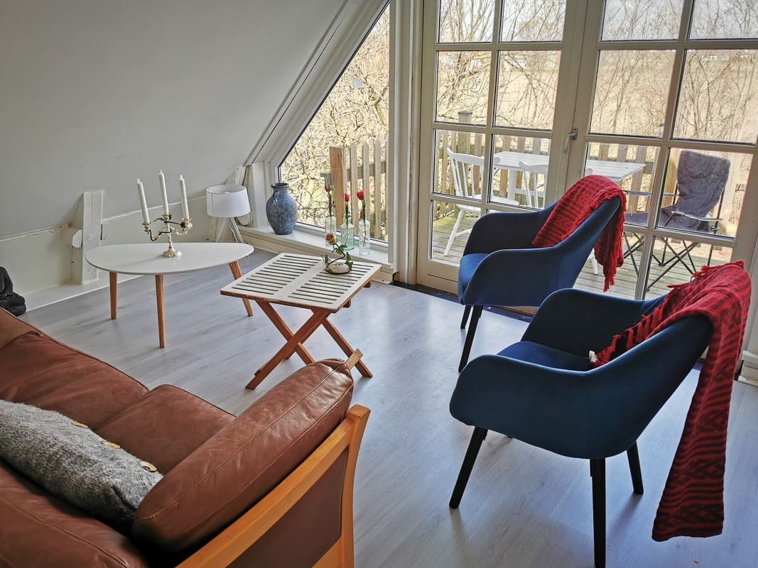 Comfortable sitting area with balcony view at Yogi Living Guesthouse in Skåne, Sweden