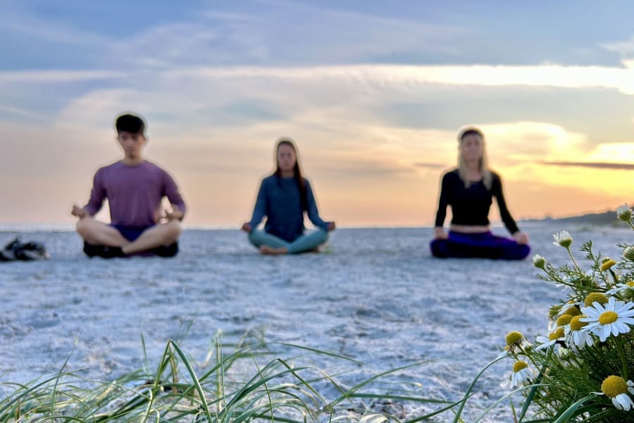 Woman meditating on a Swedish beach during the Kundalini Awakening Retreat, connecting with inner energy