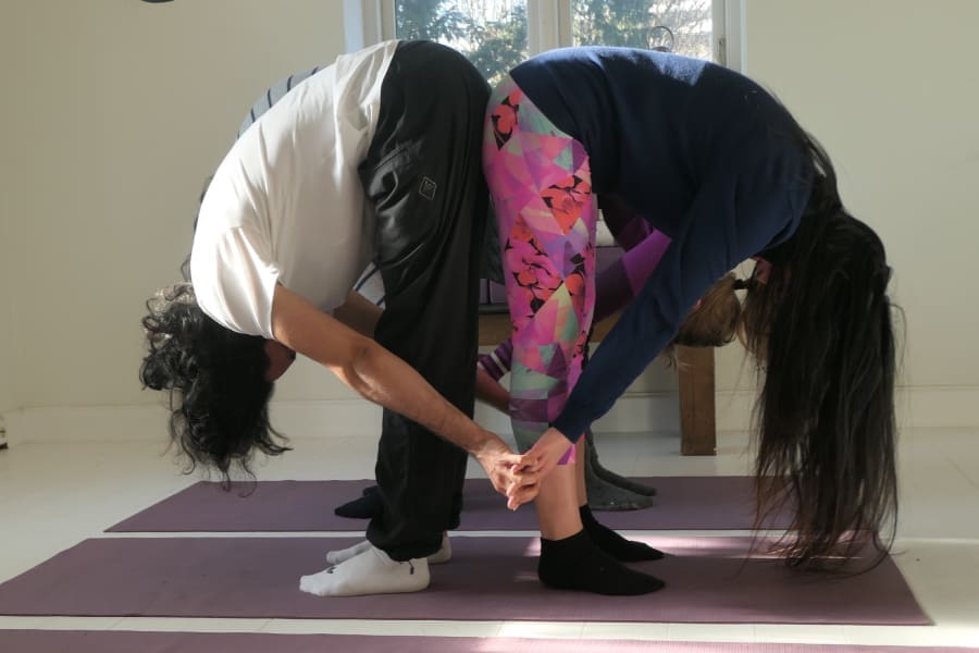 Couple practicing yoga together to strengthen connection and bonding during a couples yoga retreat in Sweden