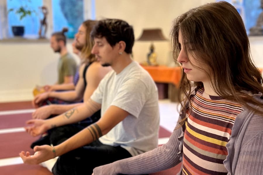Participants in a Kundalini Kriya group session at the Kundalini Awakening Retreat in Sweden, focusing on mindfulness and inner energy