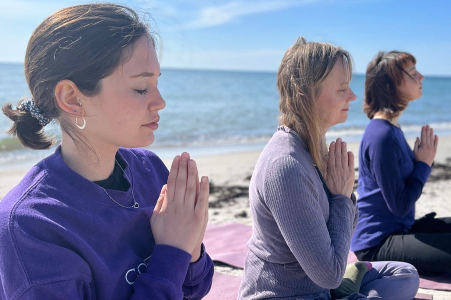 Women meditating quietly by the sea during a silent retreat in Sweden