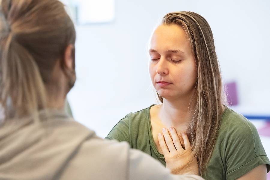Couple in heart-to-heart meditation at Tantra retreat in Sweden, surrounded by peace and bliss.