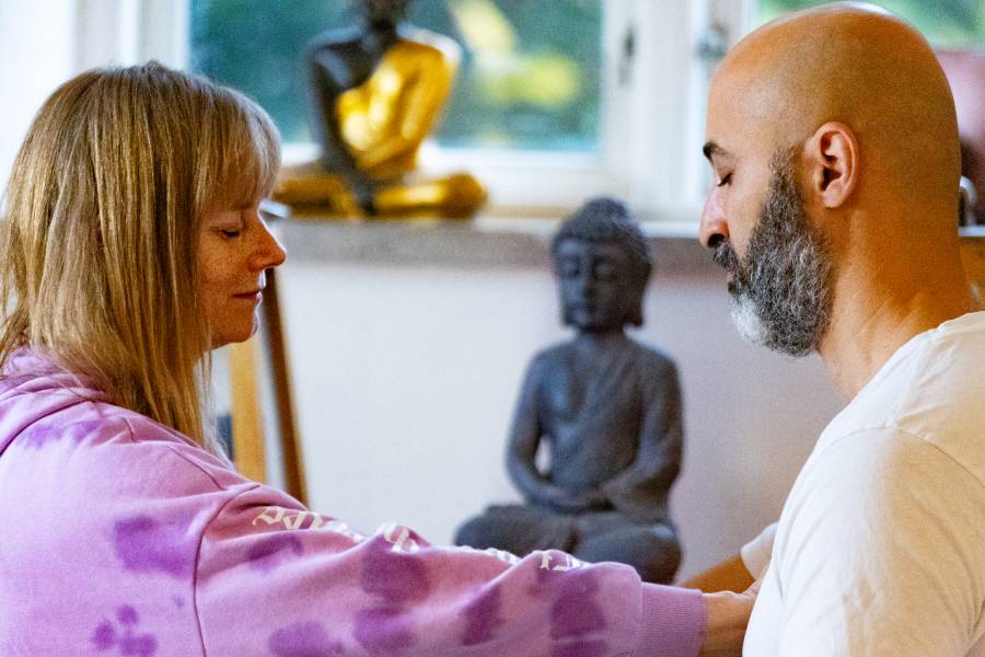 Couple in heart-to-heart meditation at Tantra retreat in Sweden, surrounded by peace and bliss.